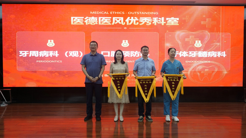 贵阳市口腔医院党委书记冯红超（左）为医德医风优秀科室颁奖。