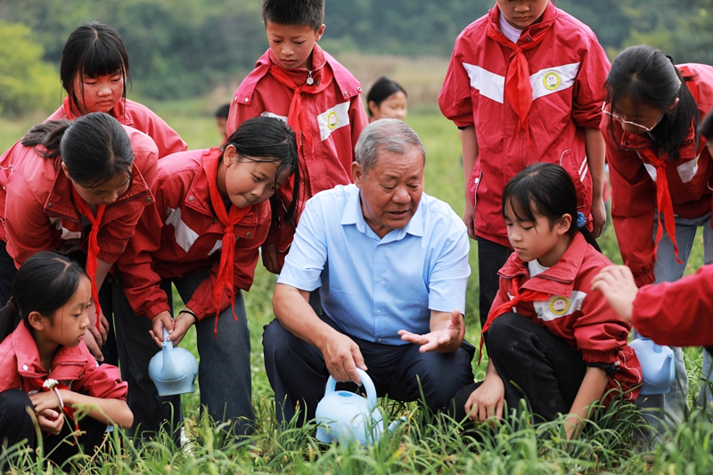 2026年9月21日，貴州省黔西市關工委老同志與學校師生一起開展勞動教育實踐活動，給韭菜澆水。