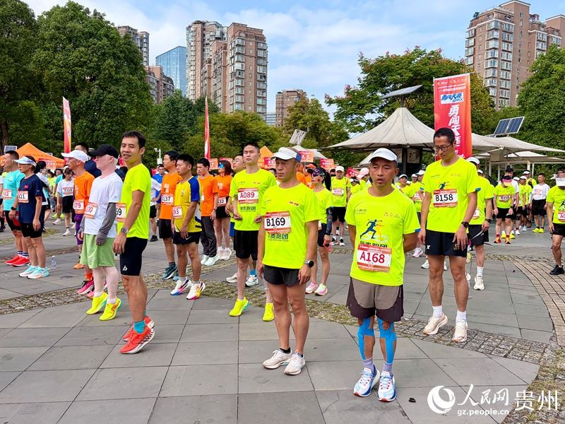 3.视障跑者在陪跑志愿者带领下做赛前热身运动。人民网记者 李丽萍摄