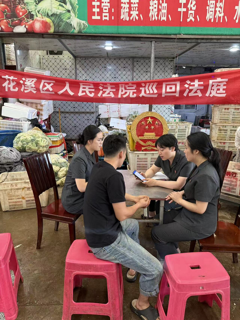 法官在园区开展巡回审判后对商户进行精准普法。
