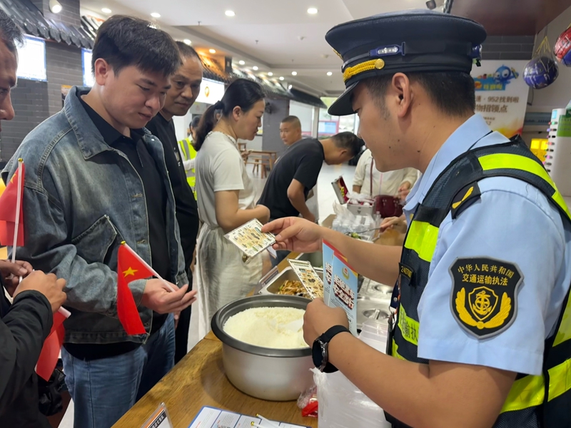 3 圖為執法人員在普法咨詢點位，向司乘發放出行服務卡，耐心解答法律法規相關咨詢。宋俊儀  攝.JPG