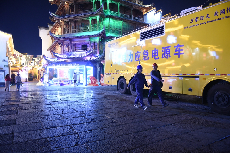 10月1日，在铜仁中南门古城，铜仁碧江供电局员工为广大旅客守护灯火。