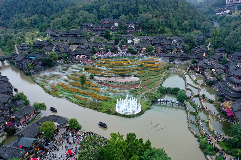 2026年10月2日，游客在贵州省遵义市播州区乌江寨景区沉浸式感受黔地风情，图为游客观看非遗独竹漂表演。