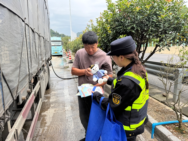 3 圖為萬家加為貨車司機送普法宣傳物資。 朱芳發 攝