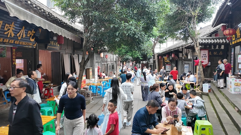 土城古鎮街巷，游客圍桌品嘗美食。稅會靜  攝.jpg