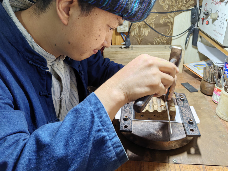 龙松在制作银手镯。