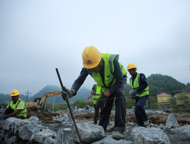 印江自治县木黄新光100MW200MWh储能电站项目建设施工现场，工人们抢节点开展围墙基础施工。梅亚军摄