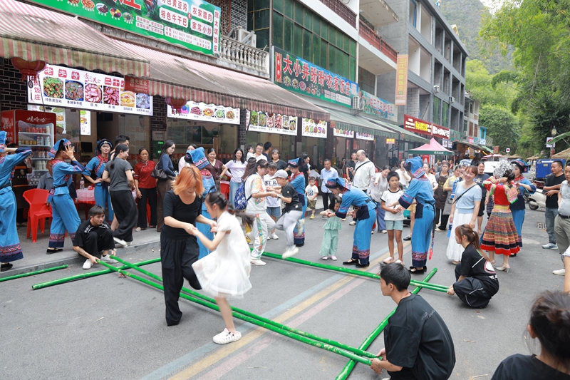 游客在大小井風景名勝區體驗竹竿舞。
