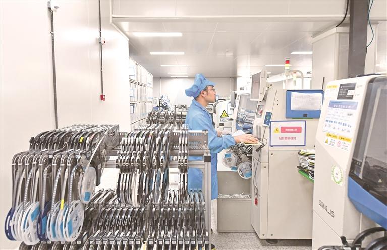 在貴陽永青智控科技股份有限公司5G＋智慧工廠車間內，工人在操作智能設備核對貼片物料。張麗攝