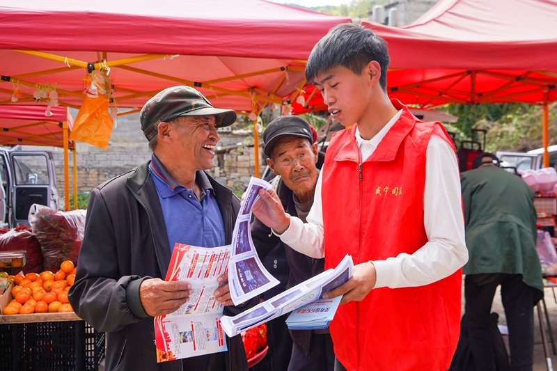 2026年11月15日，在威宁自治县哈喇河镇赶集日“摆摊接访”点，工作人员在向过往群众普及相关政策。（赵庆能 摄）.JPG