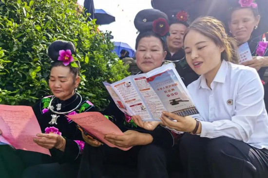 志愿者在雷山县大塘九十九爬坡节现场向群众宣传法律知识。雷山县司法局供图